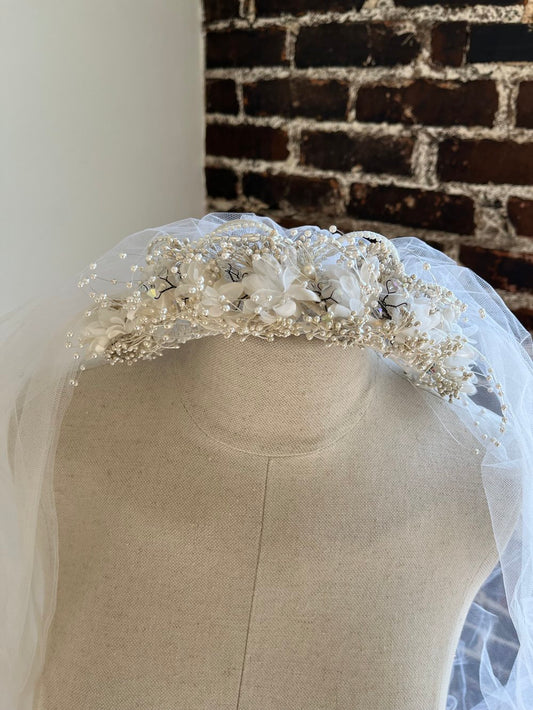 Closeup of 1980's Flower Crown with Walking Length Tulle Veil on a manakin.