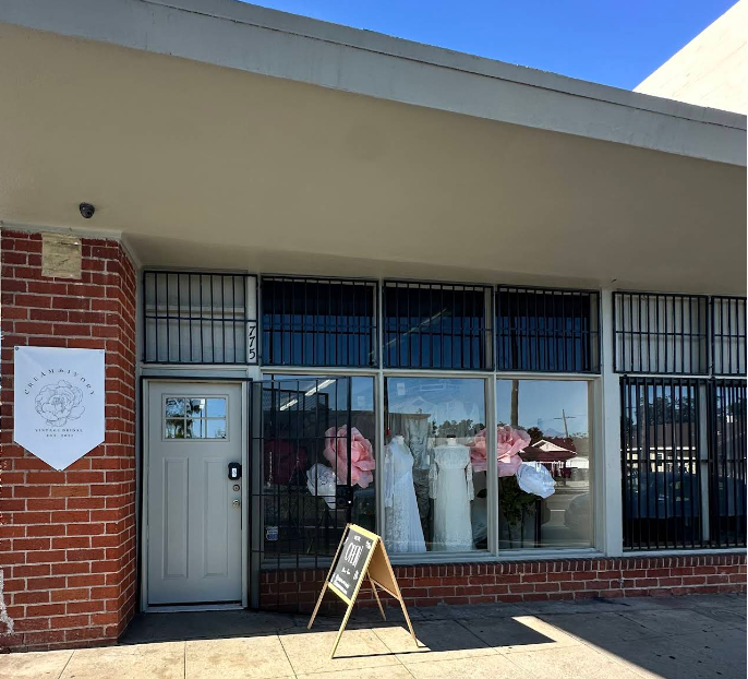 Cream & Ivory's storefront with a white door and large windows, featuring mannequins in a display.